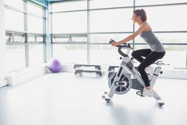 Mujer montando una bicicleta estática — Foto de Stock