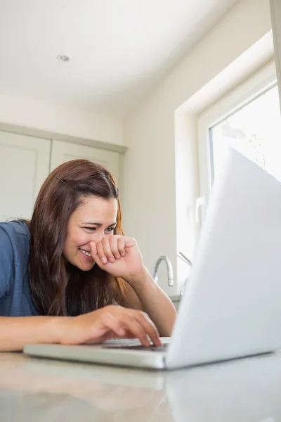 Mujer escribiendo en el ordenador portátil mientras se ríe —  Fotos de Stock