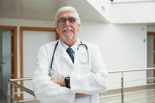 Doctor standing in the corridor smiling — Stock Photo, Image