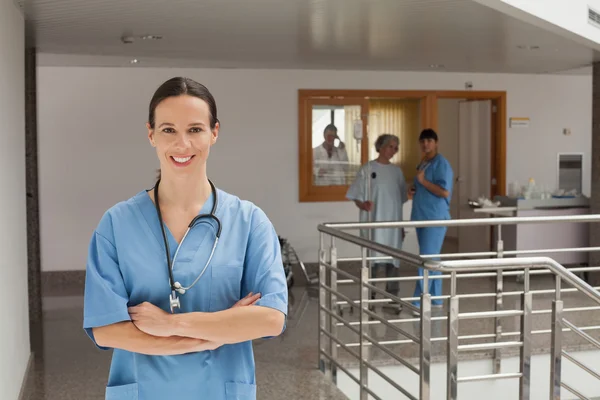 Leende läkare står i korridoren — Stockfoto