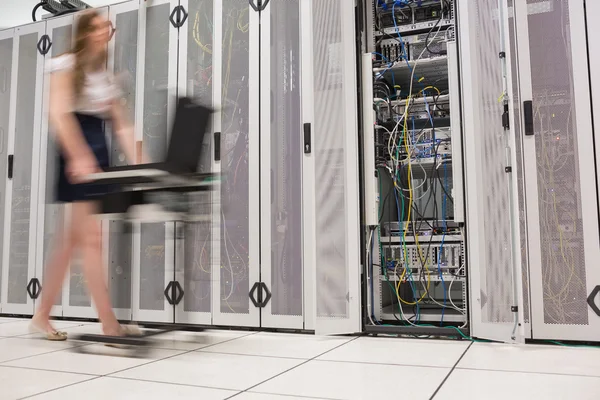 Mulher empurrando computador através de data center — Fotografia de Stock