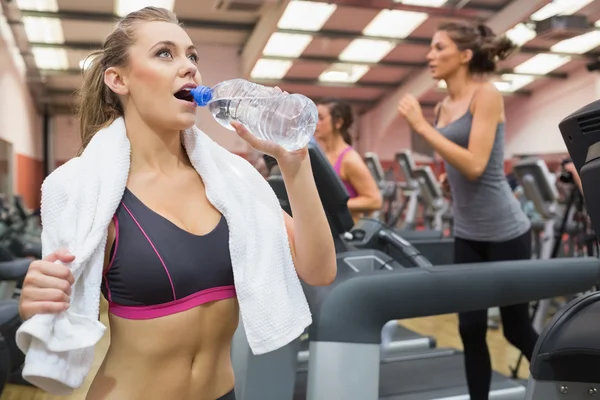 Mujer bebiendo agua en el gimnasio — Foto de Stock