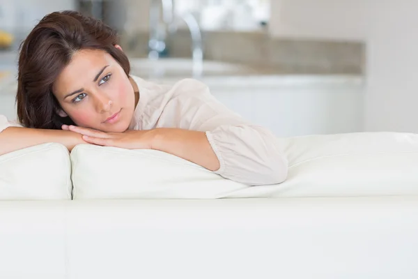 Thoughtful woman relaxing on the couch — Stock Photo, Image