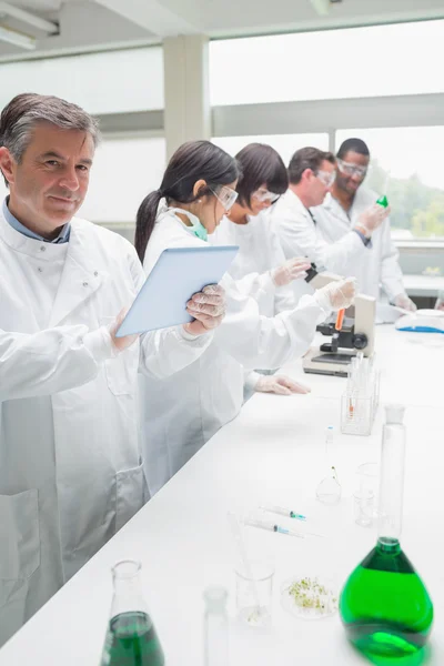 Happy chemist using tablet pc — Stock Photo, Image