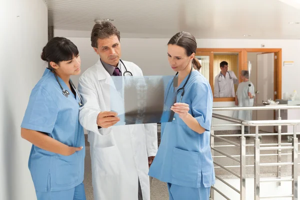 Drei Ärzte betrachten ein Röntgenbild — Stockfoto
