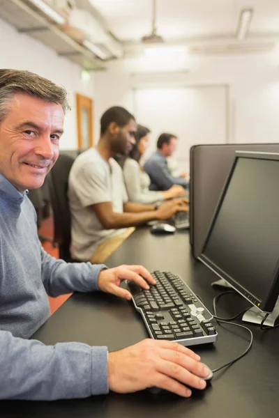 Lächelnder Mann, der mit dem Computer arbeitet — Stockfoto