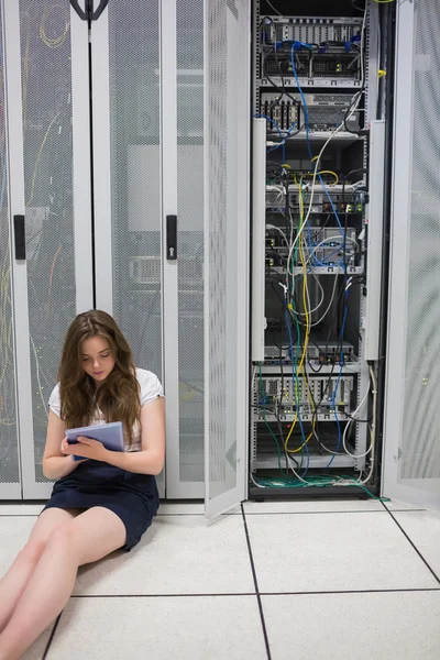 Woman working on servers with tablet pc sitting on floor — Stock Photo, Image