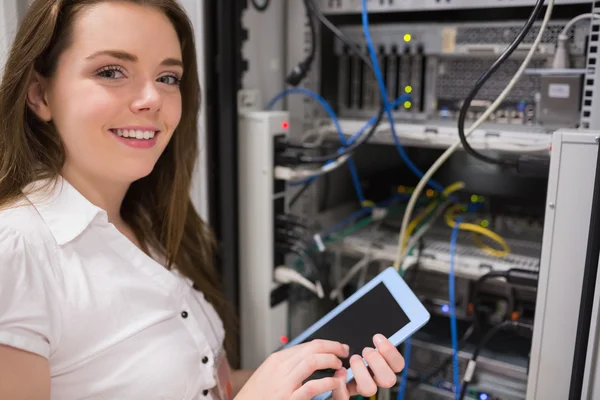 Frau steht vor Datenspeicher und hält Tablet in der Hand — Stockfoto