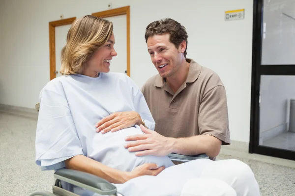 Pregnant woman in wheelchair talking with partner — Stock Photo, Image