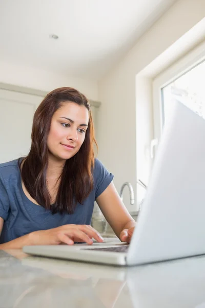 Brünette tippt auf Laptop — Stockfoto