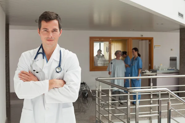 Sorridente medico in piedi nel corridoio — Foto Stock