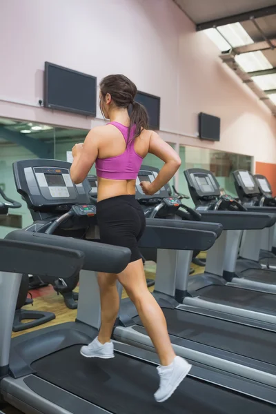 Mujer corriendo en una cinta de correr en un gimnasio —  Fotos de Stock