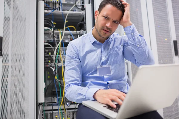 Técnico ficando frustrado com laptop sobre servidores — Fotografia de Stock