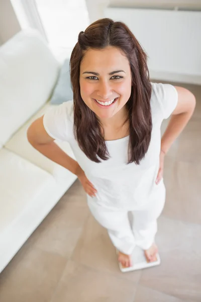 Brunette standing on weighing scales — Stock Photo, Image