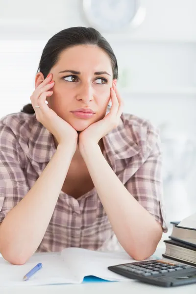 Boos vrouw met boeken en rekenmachine Stockfoto