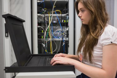 Woman running diagnostics on servers clipart
