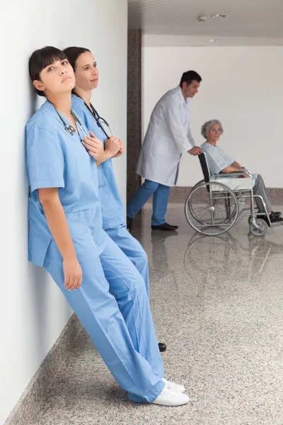 Twee verpleegkundigen leunend op de muur — Stockfoto