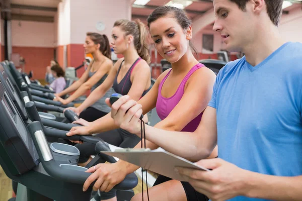 Instructor showing stopwatch in gym — Stock Photo, Image