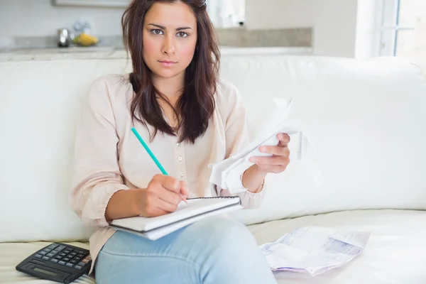 Young woman looking stressed over bills — Stock Photo, Image