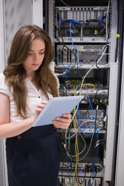 Frau überprüft Server mit Tablet-PC — Stockfoto