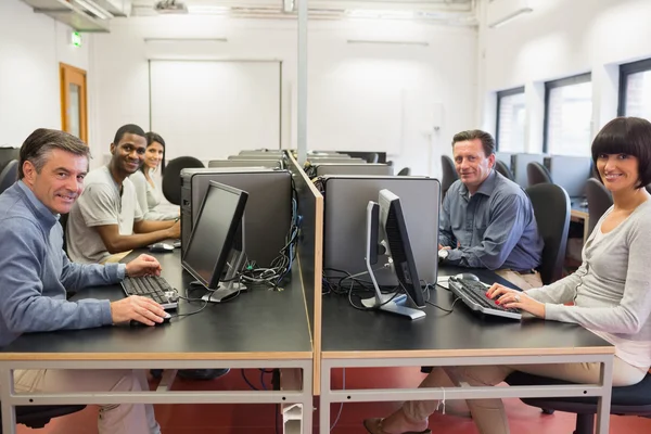 Grupo feliz em uma sala de informática — Fotografia de Stock