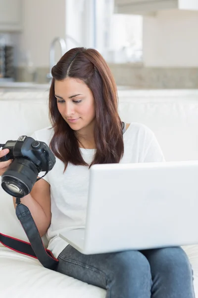 Woman viewing photos while holding a laptop — Stock Photo, Image