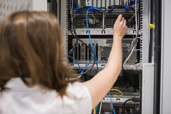 Woman fixing wires of servers — Stock Photo, Image