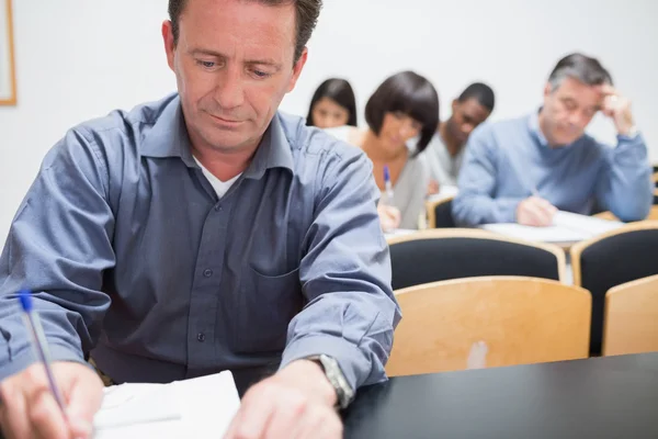 Volwassen groep aantekeningen in de klas — Stockfoto