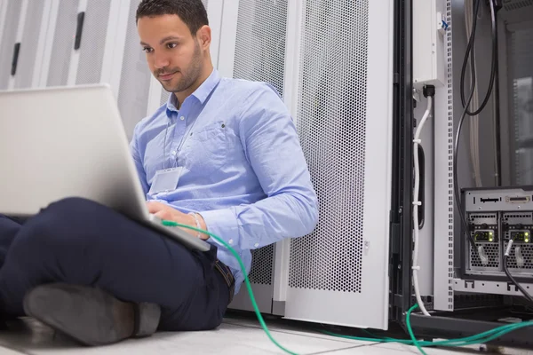 Homem se concentrando em laptop conectado ao servidor — Fotografia de Stock