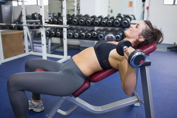 Woman training with weights while lying — Stock Photo, Image