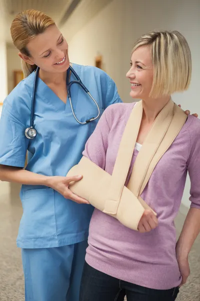 Νοσοκόμα που είναι χαμογελώντας με ασθενή σε χέρι σφεντόνα护士与病人的手臂吊袋微笑 — 图库照片