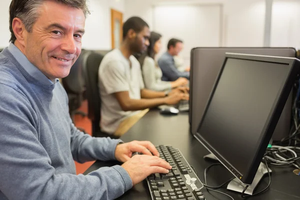 Sorrindo homem sentado na frente do computador — Fotografia de Stock