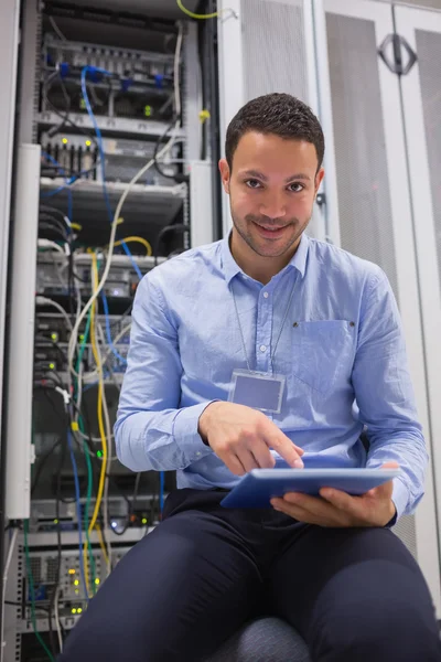 Técnico trabalhando em tablet pc ao lado de servidores — Fotografia de Stock