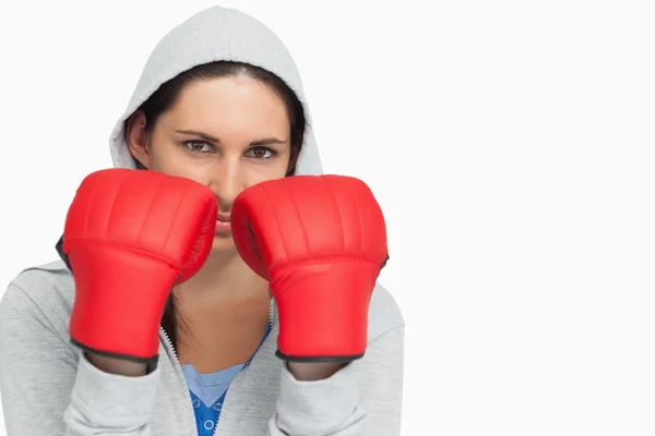 Brunette woman in sweatshirt wearing boxing gloves — Stock Photo, Image
