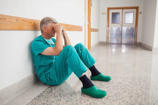 Doctor is sitting on the floor with hands in his face — Stock Photo, Image