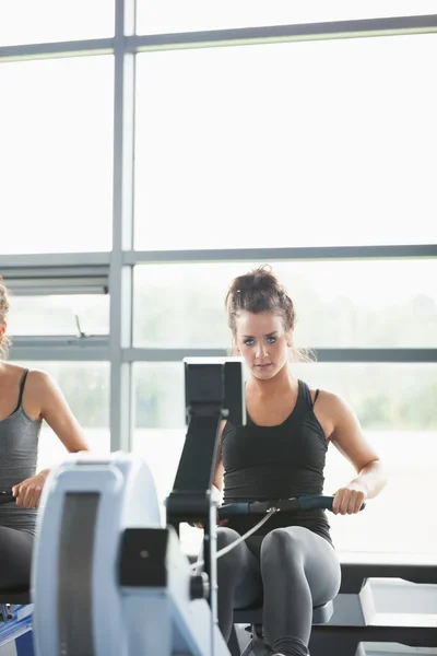 Duas mulheres treinando em máquinas de fileira — Fotografia de Stock