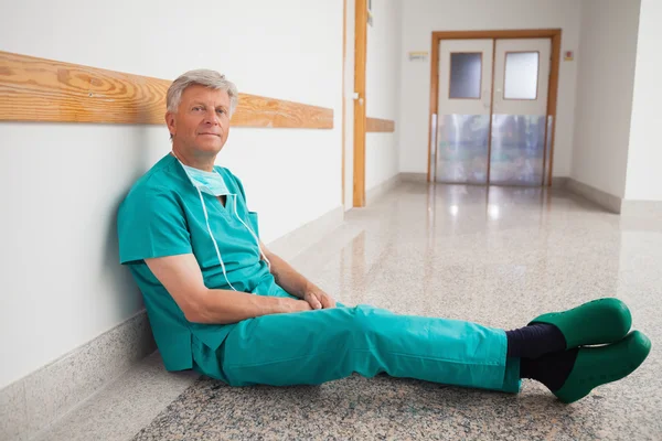 Médico sentado no chão sorrindo — Fotografia de Stock