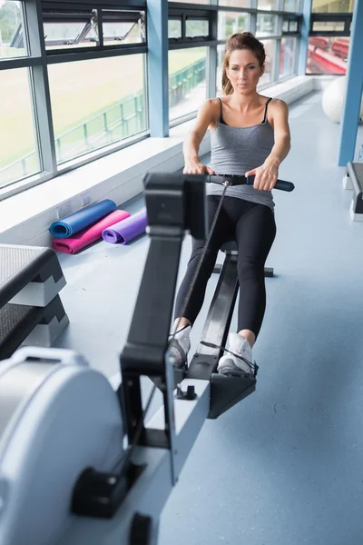 Morena mujer entrenamiento en fila máquina — Foto de Stock