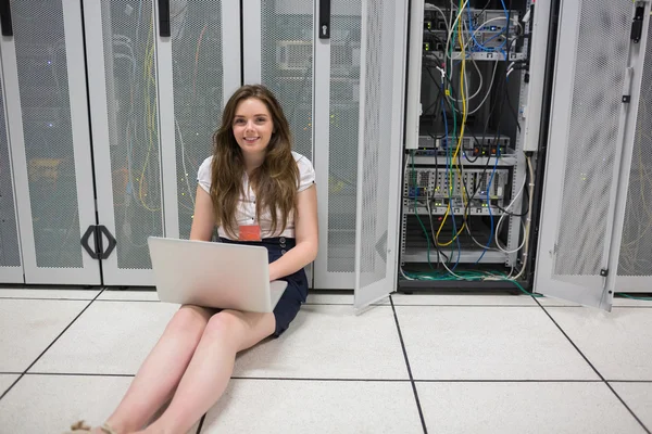 Frau überprüft auf dem Boden sitzende Server — Stockfoto