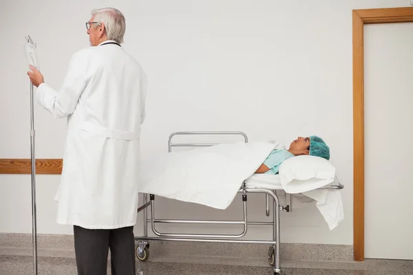 Médico ajustando pacientes I.V gotejamento — Fotografia de Stock