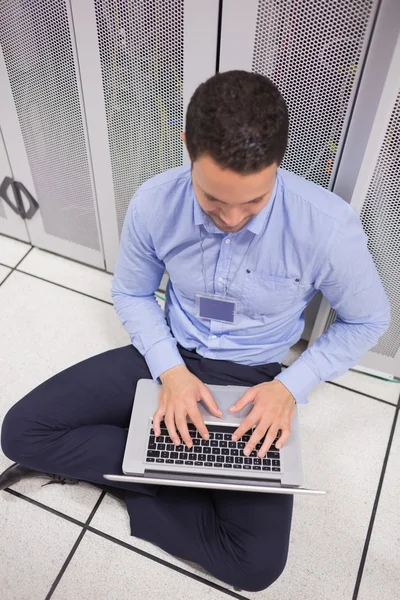 Homem usando seu laptop no data center — Fotografia de Stock