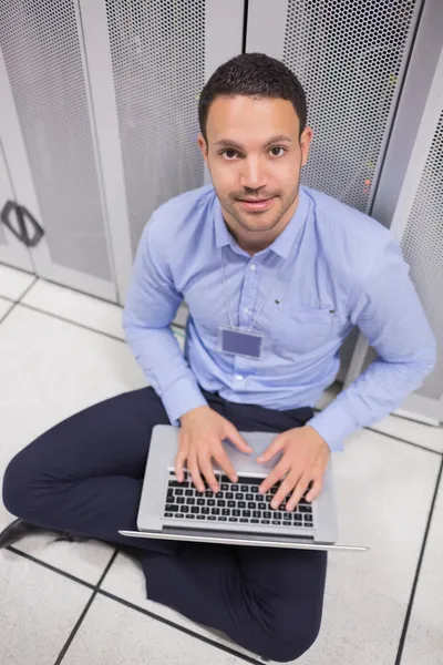 Sorrindo homem usando laptop na frente de servidores — Fotografia de Stock