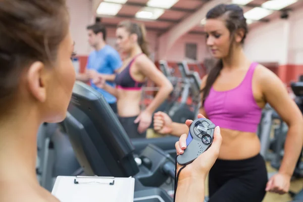 Instructeur utilisant chronomètre dans la salle de gym — Photo