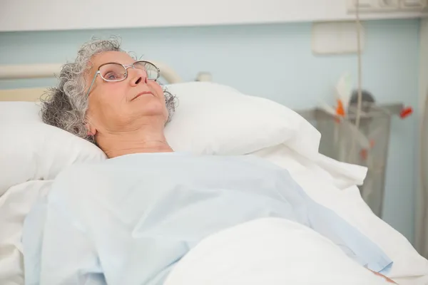 Старуха лежит на больничной койке — стоковое фото