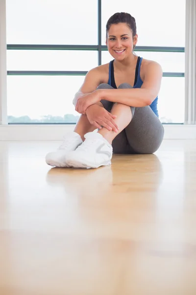 Kobieta siedzi w studiu fitness — Zdjęcie stockowe