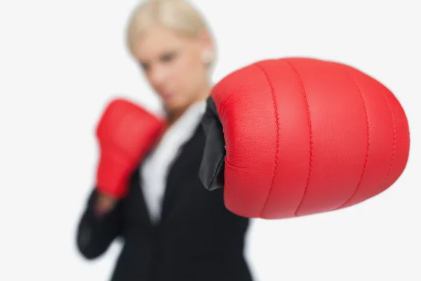 Mujer de negocios rubia con guantes de boxeo rojo luchando — Foto de Stock