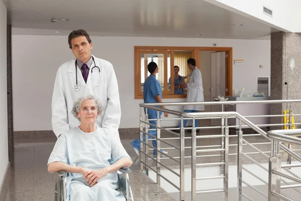 Médico empurrando uma mulher — Fotografia de Stock