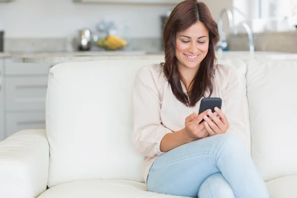 Brunette texting met mobiele telefoon — Stockfoto