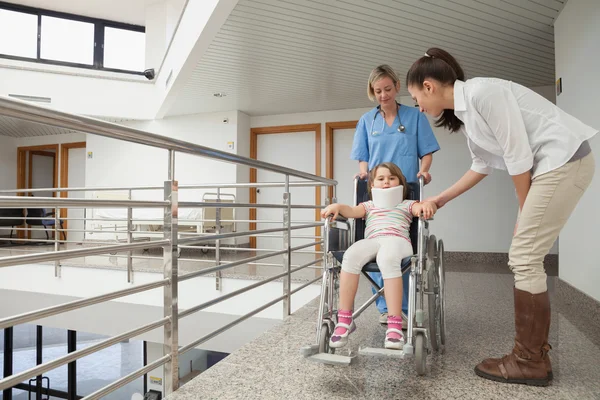 Sjuksköterska driftigt barn i rullstol med mamma — Stockfoto