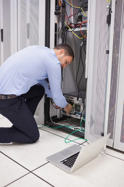 Homem fazendo manutenção e fixação de fios no servidor — Fotografia de Stock